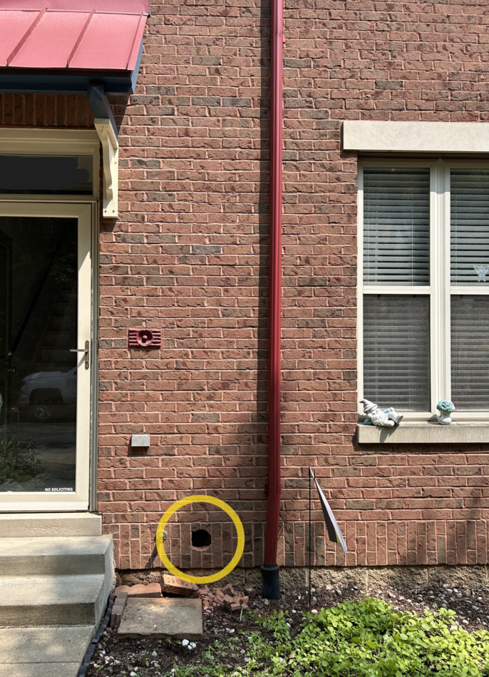 Photo of a core drilled hole on the front of a brick row house