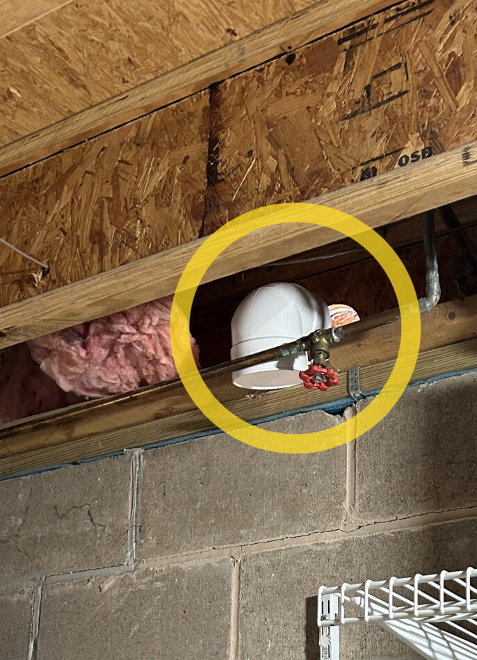 Photo of hole drilled through front wall of home for radon discharge exit, as viewed from inside the basement.