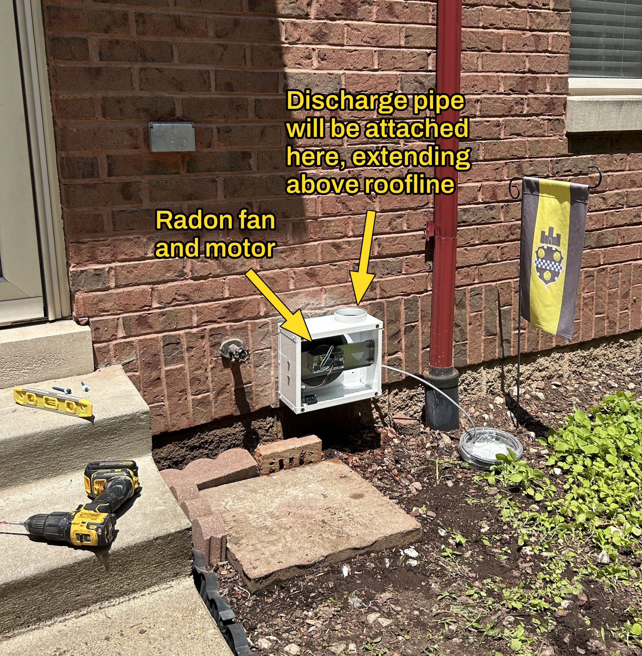 Photo showing exterior radon fan installation and electrical connection