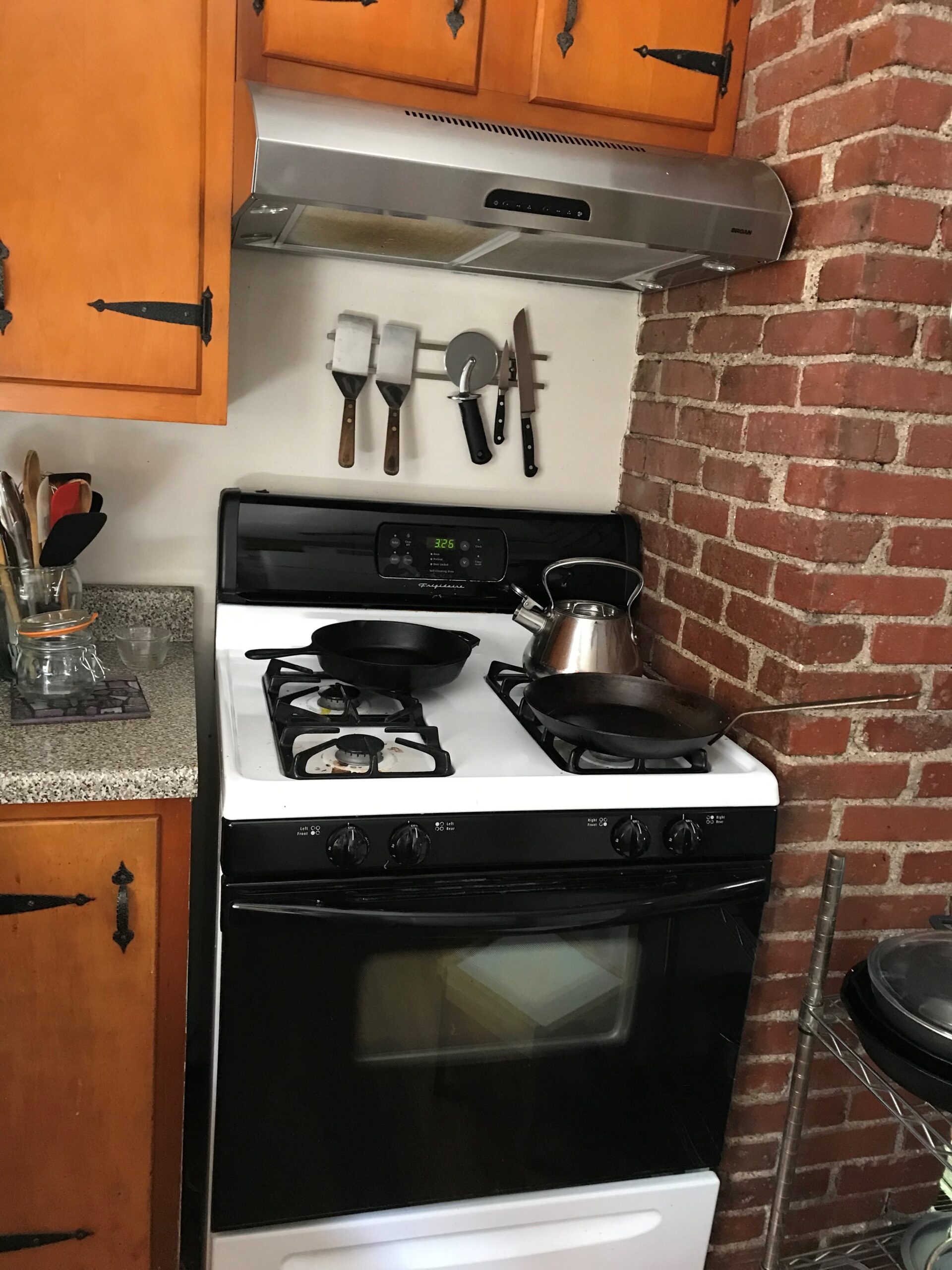 A kitchen range hood and stovetop with pans