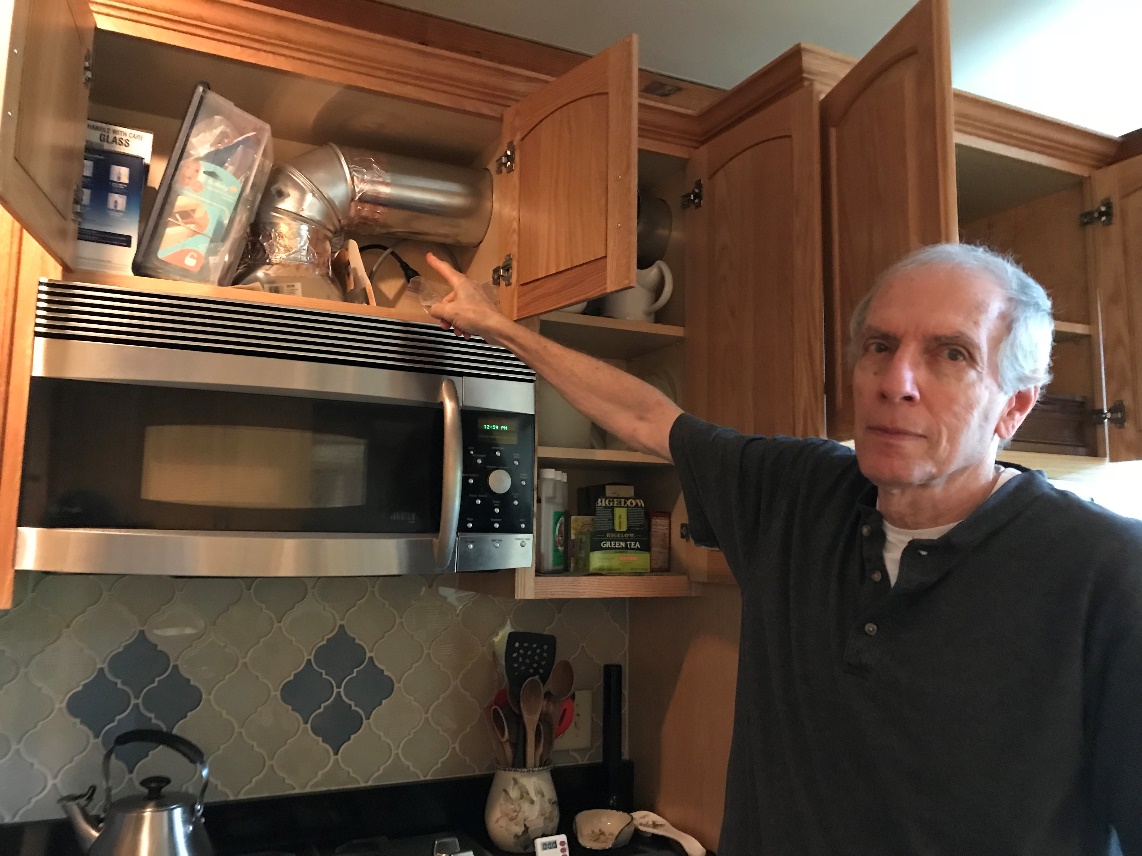Brian pointing to ductwork above stove