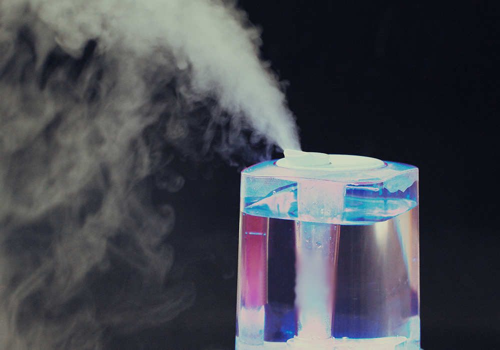 A humidifier in operation, billowing steam against a black background.