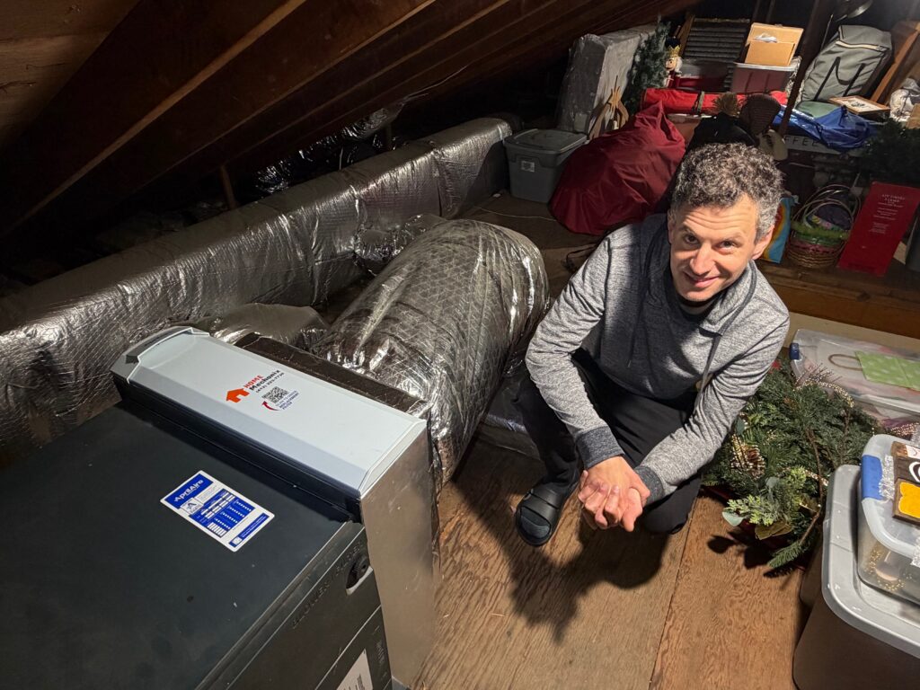 Photo of Richard posing next to his modified attic AC system