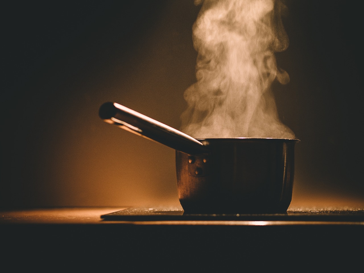 A single pot on a cooking surface with steam coming from it